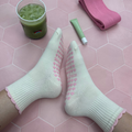 Cream sock with a pink ruffle and pink heart grips